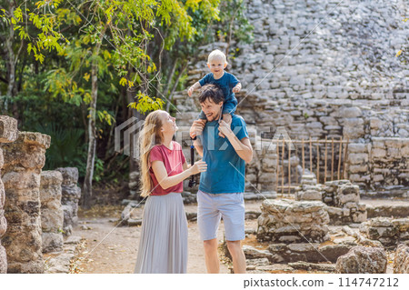 Mom, dad and baby tourists at Coba, Mexico. Ancient mayan city in Mexico. Coba is an archaeological area and a famous landmark of Yucatan Peninsula. Cloudy sky over a pyramid in Mexico 114747212