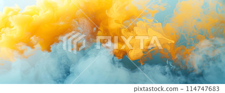 Dynamic and vibrant interplay of yellow and orange ink diffusing into water against soft blue background, creating abstract and fluid visual effect that is both striking and ethereal 114747683