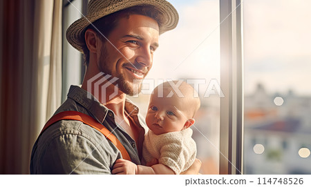 a dad tenderly holds his baby in his arms. 114748526