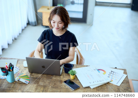 一位女設計師在家用電腦工作 114748660