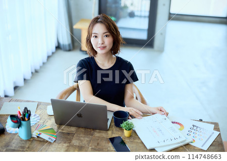 一位女設計師在家用電腦工作 114748663