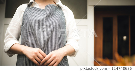 A woman wearing an apron A woman wearing an apron 114748686