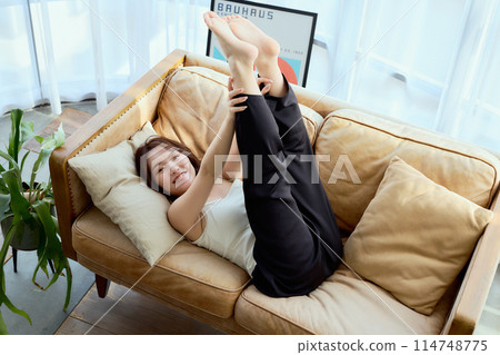 一個女人躺在沙發上抬起雙腿 114748775