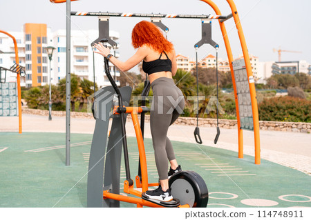 Fit woman exercising with exercise equipment in 114748911