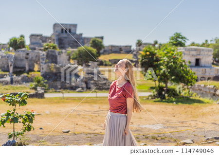 Woman tourist enjoying the view Pre-Columbian Mayan walled city of Tulum, Quintana Roo, Mexico, North America, Tulum, Mexico. El Castillo - castle the Mayan city of Tulum main temple Woman tourist enjoying the view Pre-Columbian Mayan walled city of Tulum, Quintana Roo, Mexico, North America, Tulum, Mexico. El Castillo - castle the Mayan city of Tulum main temple 114749046