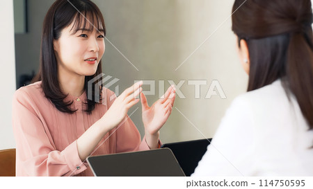 Group of women in casual wear having a conversation in the office Group of women in casual wear having a conversation in the office 114750595