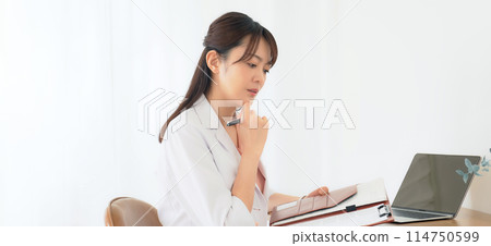 A middle-aged woman in a white coat thinking A middle-aged woman in a white coat thinking 114750599