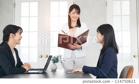 Three businesswomen having a meeting in a casual office Three businesswomen having a meeting in a casual office 114750621