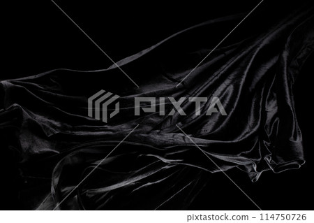 Black velvet felt fabric flying in curve shape, Piece of textile black velvet felt fabric throw fall in air. Black background isolated, dark shading environment 114750726
