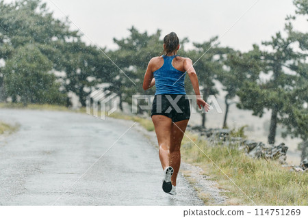 Unstoppable: A Determined Athlete Trains Through the Rain in Pursuit of Marathon Glory 114751269
