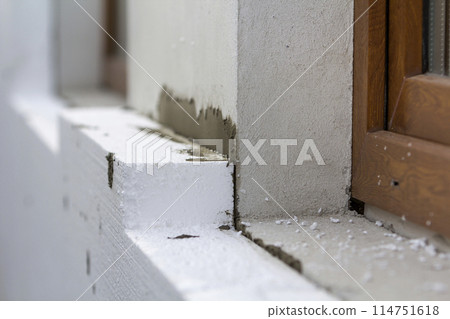 Close-up detail of plastered house wall with rigid styrofoam insulation. Modern technology, construction, renovation, energy saving, alternative for mineral wool, warm comfortable house concept. 114751618