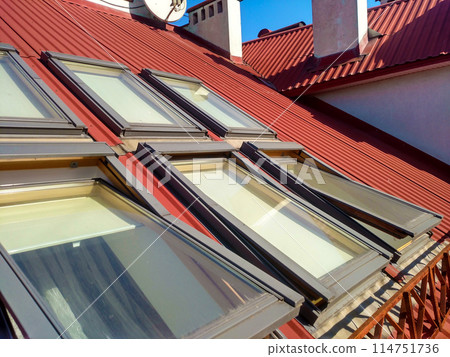 Red tiled house roof with attic windows. Roofing construction, window installation, modern architecture concept. Red tiled house roof with attic windows. Roofing construction, window installation, modern architecture concept. 114751736