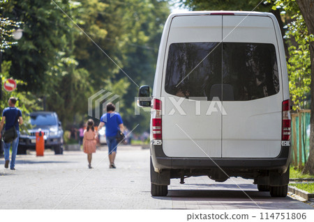 Back view white passenger medium size commercial luxury minibus van parked on summer city street. Back view white passenger medium size commercial luxury minibus van parked on summer city street. 114751806
