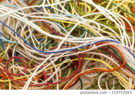 Multi-colored tangled colorful needlecraft silk thread rope. Macro shot. Abstract colors background 114752003