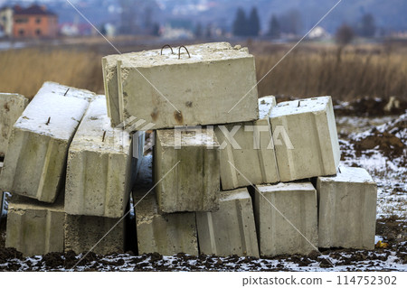 Stack of concrete blocks for foundation on construction site. Ferroconcrete reinforced with metal blocks 114752302