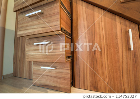 Modern architecture interior with luxury hallway with glossy wooden stairs in modern storey house. Custom built pullout cabinets on glides in slots under stairs Modern architecture interior with luxury hallway with glossy wooden stairs in modern storey house. Custom built pullout cabinets on glides in slots under stairs 114752327