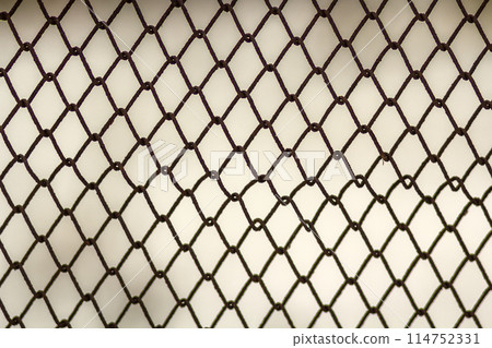 Background and texture for design. Abstract chain link fence texture against grungy gray color wall. Background and texture for design. Abstract chain link fence texture against grungy gray color wall. 114752331