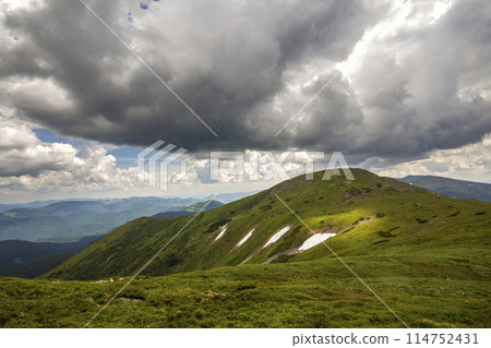 Mountain ridge landscape under dramatic cloudy sky, summer or spring wide panoramic view. 114752431