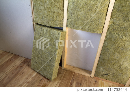 Wooden frame for future walls with drywall plates insulated with rock wool and fiberglass insulation staff for cold barrier. Comfortable warm home, economy, construction and renovation concept. 114752444