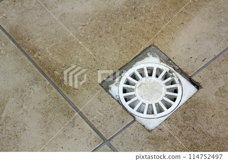 Water drain vent in kitchen, bathroom or basement ceramic tiled old vintage floor. Geometric abstract beige background. 114752497