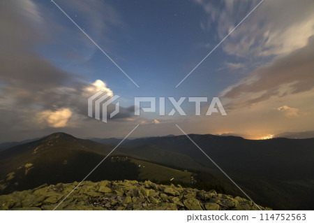 Summer night in mountains. Starry dark blue sky and white clouds at sunset over mountain range. Summer night in mountains. Starry dark blue sky and white clouds at sunset over mountain range. 114752563