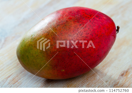 Mango fruit on wooden surface closeup Mango fruit on wooden surface closeup 114752760