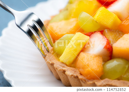 Eating fruit tart with a fork 114752852