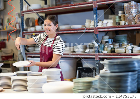 Young woman paints blanks of ceramic products Young woman paints blanks of ceramic products 114753175