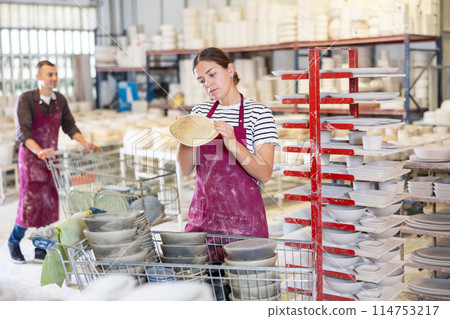 Young woman posing with ceramic dishes 114753217