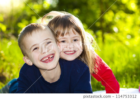 Portrait of happy smiling little children boy and girl on sunny summer grass meadow. Portrait of happy smiling little children boy and girl on sunny summer grass meadow. 114753312