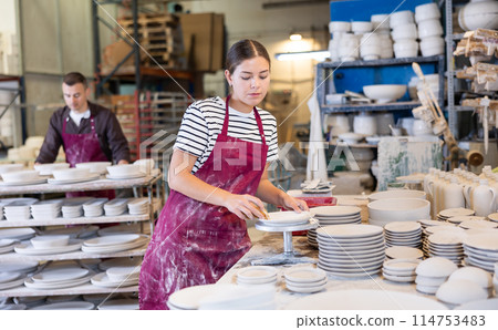 Young woman cleaning blanks of ceramic products Young woman cleaning blanks of ceramic products 114753483