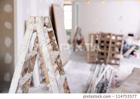 Stepladder and other repair tools in repaired room 114753577