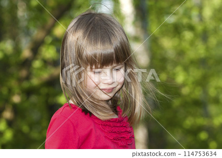 Close-up portrait of cute pretty smiling child girl with gray eyes and long fair hair on blurred sunny summer green and blue bokeh background. Beauty, dreams and innocence of childhood. Close-up portrait of cute pretty smiling child girl with gray eyes and long fair hair on blurred sunny summer green and blue bokeh background. Beauty, dreams and innocence of childhood. 114753634