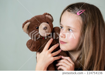 Pretty child girl playing with her teddy bear toy. 114754136