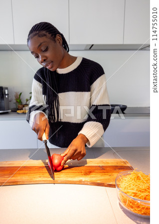 Healthy Home Cooking: Young Black Woman Preparing a Meal 114755010