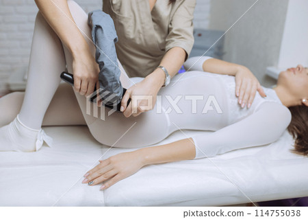 Beautiful woman getting beauty therapy against cellulite with LPG machine on her butt. LPG massage for lifting body. Beautiful woman getting beauty therapy against cellulite with LPG machine on her butt. LPG massage for lifting body. 114755038