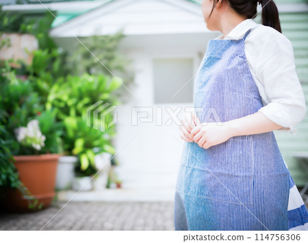 A woman wearing an apron 114756306