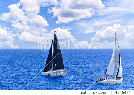Boat, sailboat sailing on the beach of Mallorca under a blue sky with white clouds	 114756435