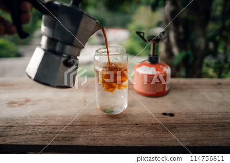 Make iced coffee from a moka pot and pour it into a glass. 114756811
