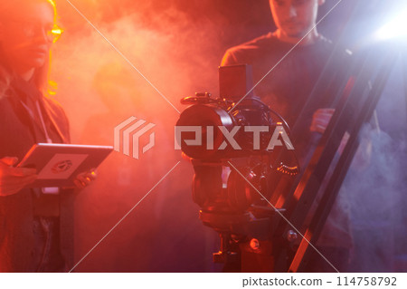 Background image of pro video camera equipment backstage in red neon light, copy space Background image of pro video camera equipment backstage in red neon light, copy space 114758792