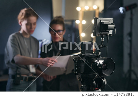 Background image of pro digital video camera on stand in video production with women working in blurred background copy space 114758913