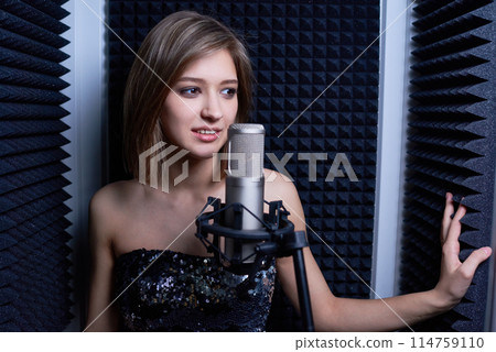 Smiling young woman recording her vocal for new track 114759110