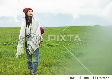 Backpacker walking through the grassland Backpacker walking through the grassland 114759836