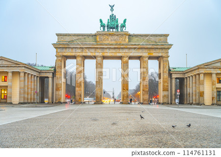 The Brandenburg Gate stands prominently at dawn, the early light accentuating its historic architecture. Berlin, Germany 114761131