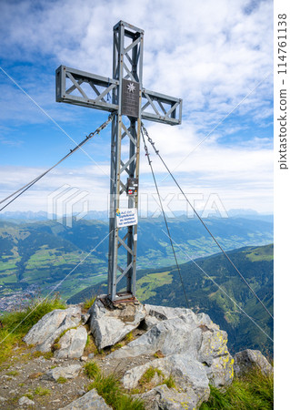 A cross marks the summit of Pihapper Mountain against a backdrop of sweeping alpine vistas. Hohe Tauern, Austria A cross marks the summit of Pihapper Mountain against a backdrop of sweeping alpine vistas. Hohe Tauern, Austria 114761138