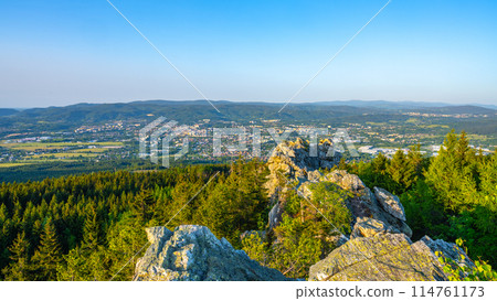 Liberec City and Jizera Mounatins visible in the distance from the rocky ridge of the Jested Mountain during a serene summer evening. 114761173