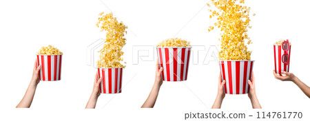 Woman hand taking popcorn from striped bucket isolated on white background 114761770