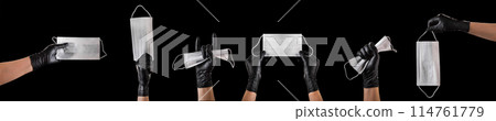 Hand in black gloves wearing disposable face mask isolated on black background Hand in black gloves wearing disposable face mask isolated on black background 114761779