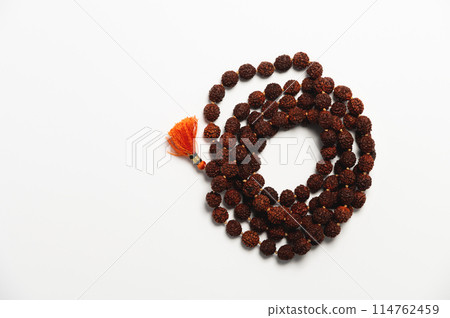 Wooden church rosary made of dark wood on a white background. Church rosary for prayer close-up 114762459
