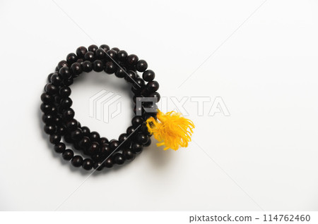 Wooden church rosary made of dark wood on a white background. Church rosary for prayer close-up Wooden church rosary made of dark wood on a white background. Church rosary for prayer close-up 114762460